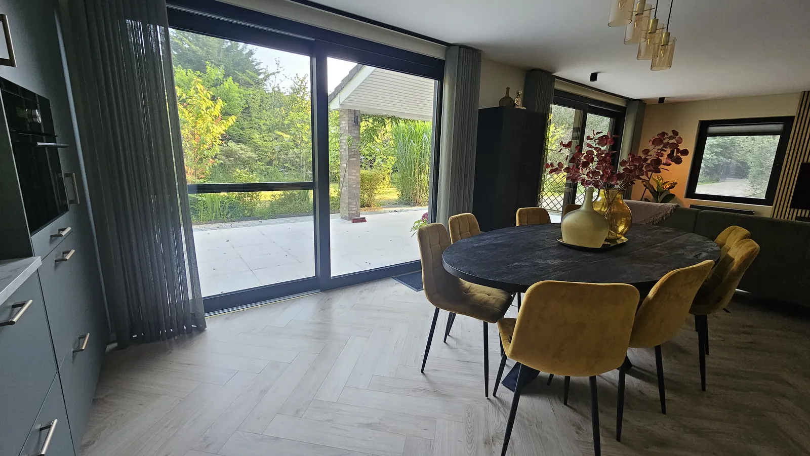 Eetkamer met grote schuifpui naar terras en tuin
