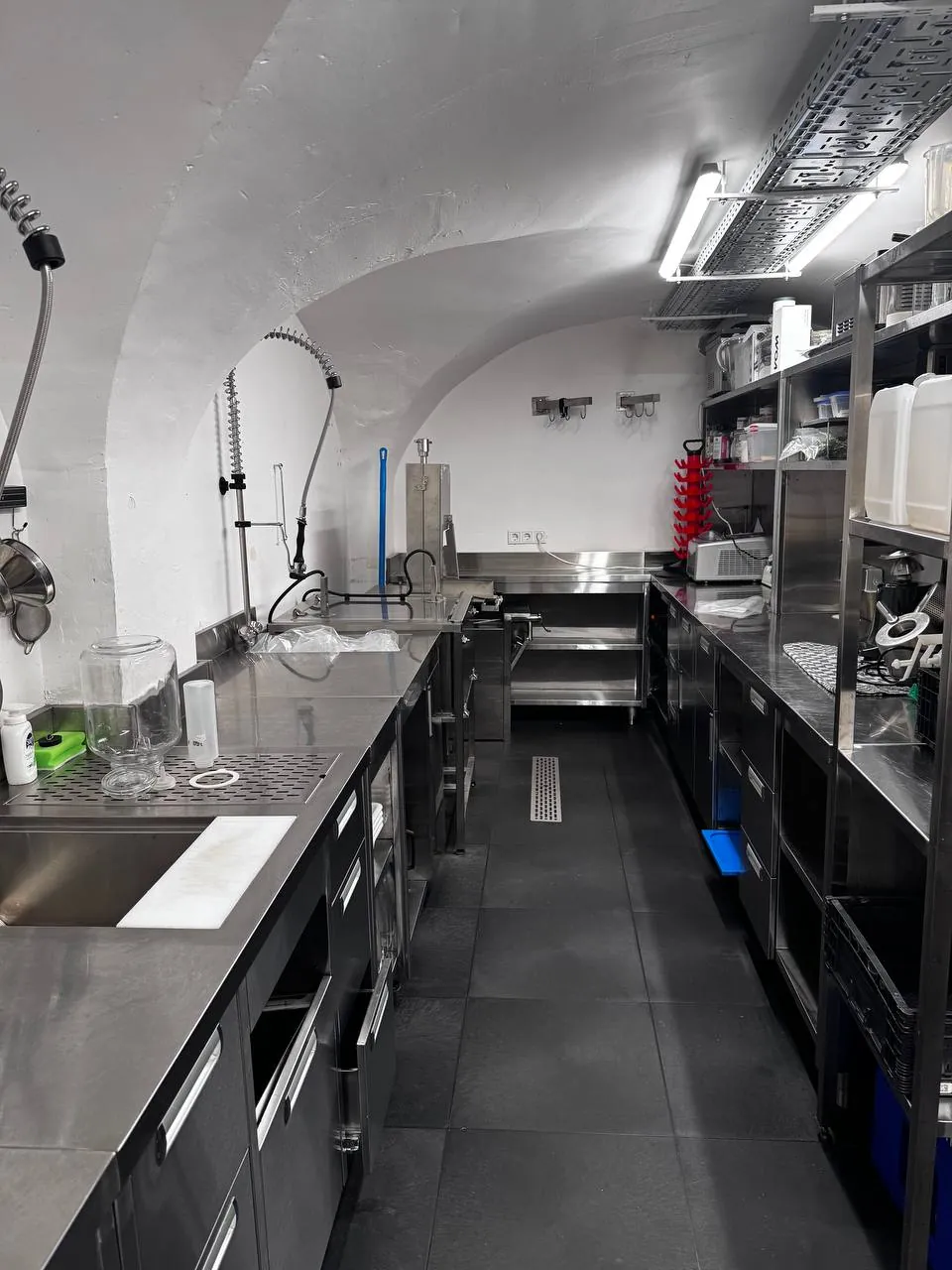Gewelfde witte professionele keuken met roestvrijstalen werkbladen