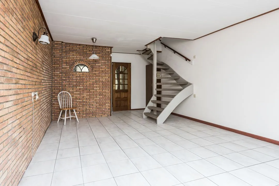 Bakstenen wand en open trap in een gerenoveerd appartement